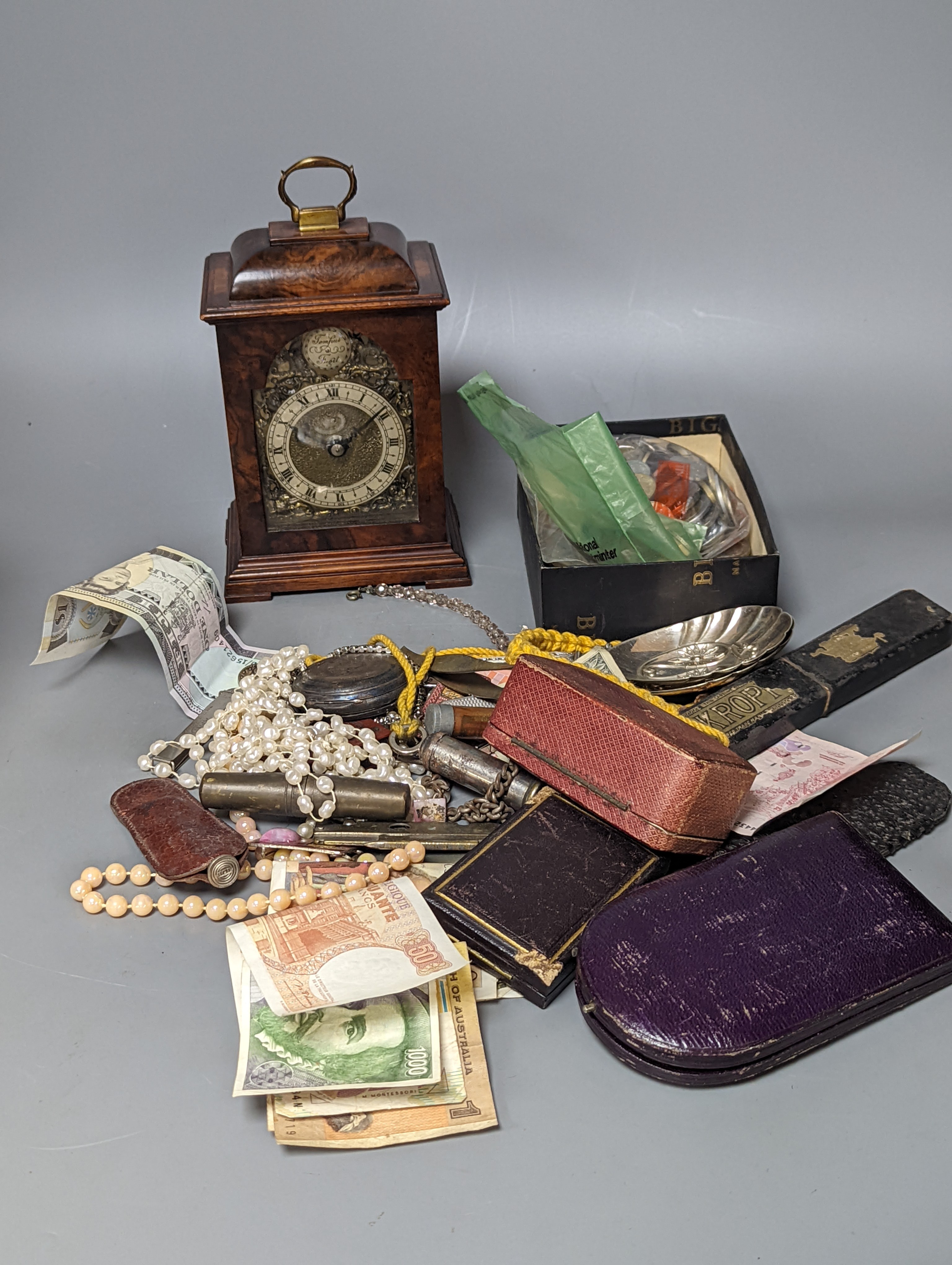 A pair of silver spoons, a small timepiece, assorted coinage and sundries